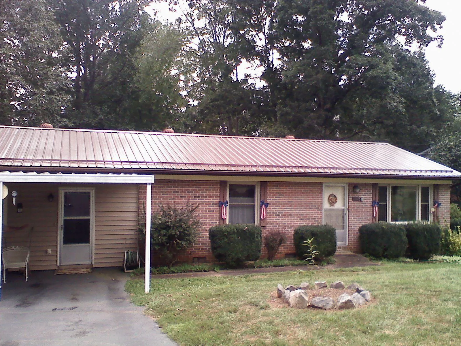 Bronze metal roof and carport on a brick ranch home — Roof Repair work by our crew in Dumont
